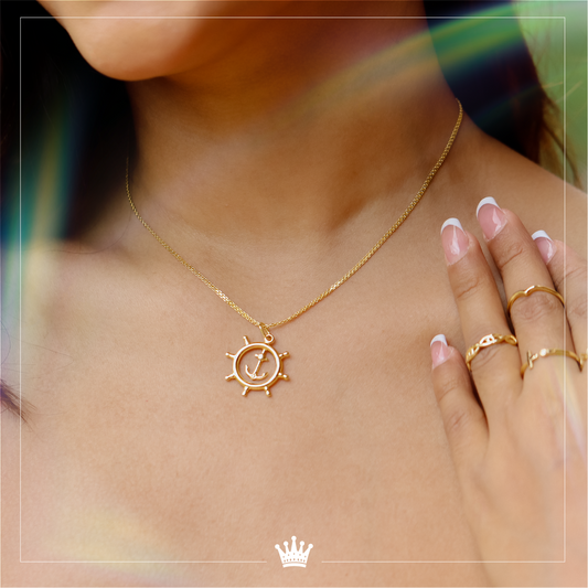 Joyas de oro 18K de Joyería Caracas diseñadas con un dije de rueda de timón y un dije de ancla. La combinación perfecta entre elegancia y funcionalidad, con garantía para toda la vida. Haz una declaración de estilo y calidad con estas exclusivas joyas.