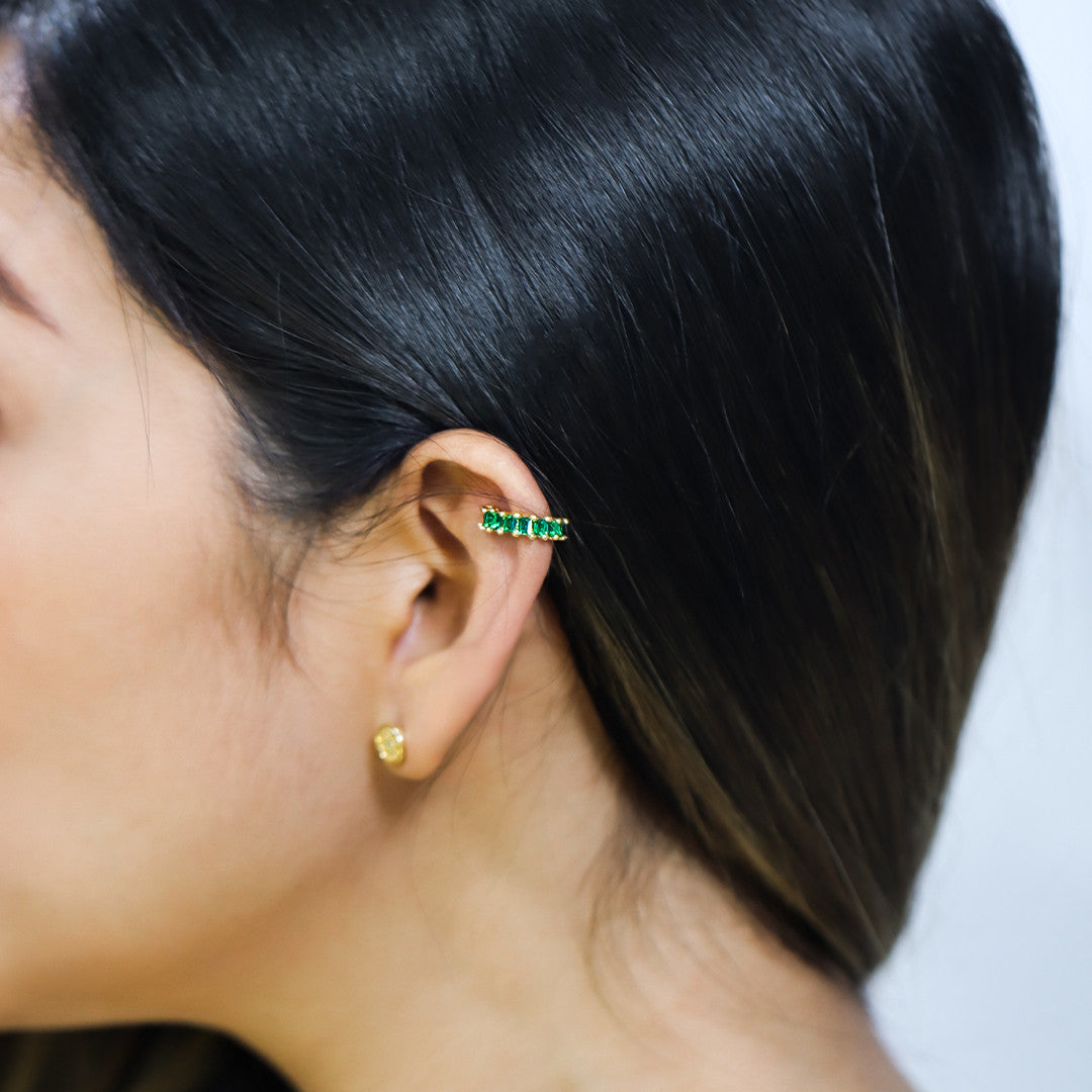 Destacando la elegancia y sofisticación de la joyería Caracas, presentamos nuestro Earcuff con piedras preciosas en un hermoso tono verde. Hecho de Oro 18K, esta pieza es una inversión para toda la vida y es respaldada por una garantía exclusiva. Inspírate en el mundo de la moda y la literatura con este accesorio exclusivo y atemporal.