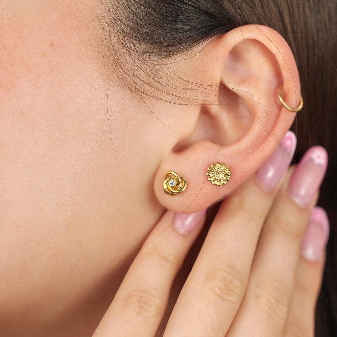 Oreja de mujer con topito en forma de espiral en oro amarillo de 18 quilates con cristal de color blanco, hechos en Joyería Caracas. 