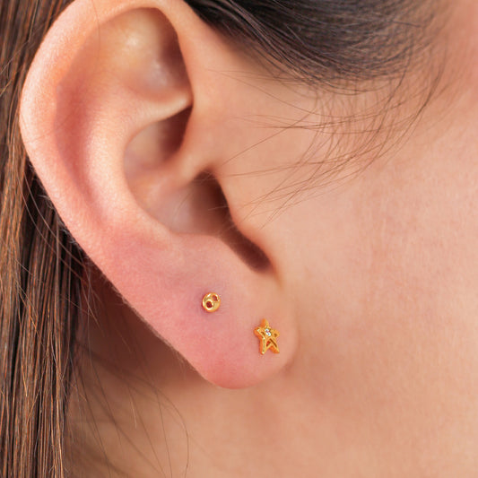 Oreja de mujer con topito en forma de estrella en oro de 18 quilates con cristal de color blanco, hechos en Joyería Caracas. 