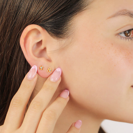 Oreja de mujer con topito de 3 aros en oro amarillo de 18 quilates con cristal de color blanco, hechos en Joyería Caracas. 