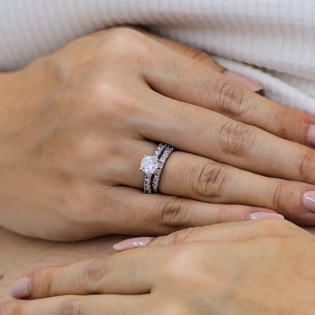 Mano la cual lleva puesto argolla y pisargolla de matrimonio con cristales blancos y hecha en oro blanco de 18 quilates en la Joyería Caracas.