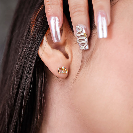 Oreja de mujer con topito de doble corazón liso en oro amarillo de 18 quilates con cristal de color blanco, hecho en Joyería Caracas. 