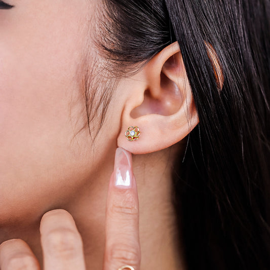 Oreja de mujer con topito en forma de flor calada en oro amarillo de 18 quilates con centro de cristal de color blanco, hecho en Joyería Caracas.