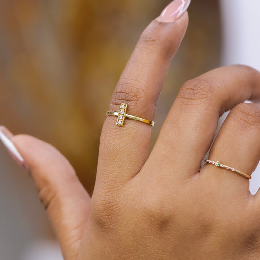 Mano de mujer con anillo en forma de T en oro amarillo de 18 quilates, hecho en Joyería Caracas. 