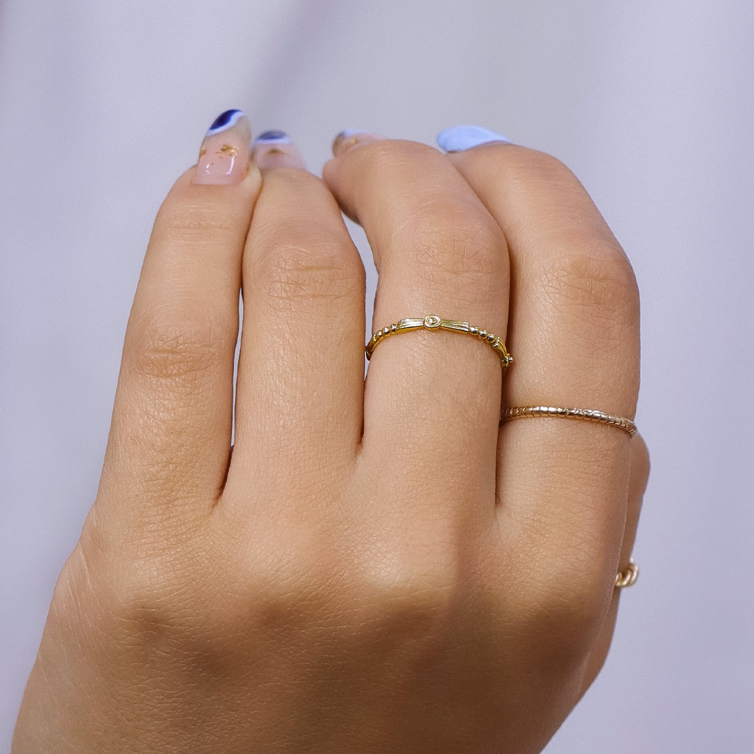 Mano de mujer con anillo en forma de fragmento en oro amarillo de 18 quilates, hecho en Joyería Caracas. 