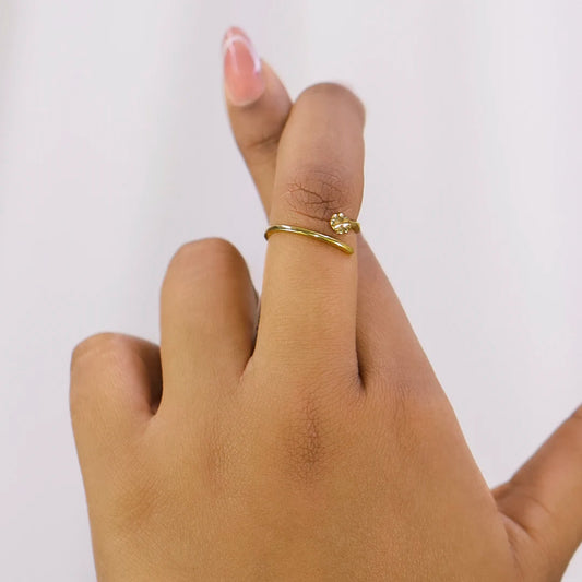 Mano de mujer con anillo en forma de trébol en oro amarillo de 18 quilates, hecho en Joyería Caracas. 