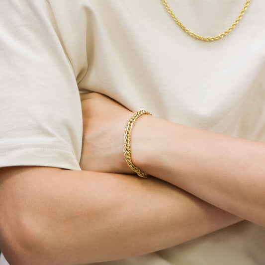 Mano de hombre con pulsera en tejido Saduza doble en oro amarillo de 18 quilates, hecho en Joyería Caracas. 