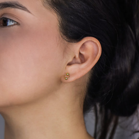 Oreja de mujer con topito aro de esfera colgante en oro amarillo de 18 quilates, hechos en Joyería Caracas. 