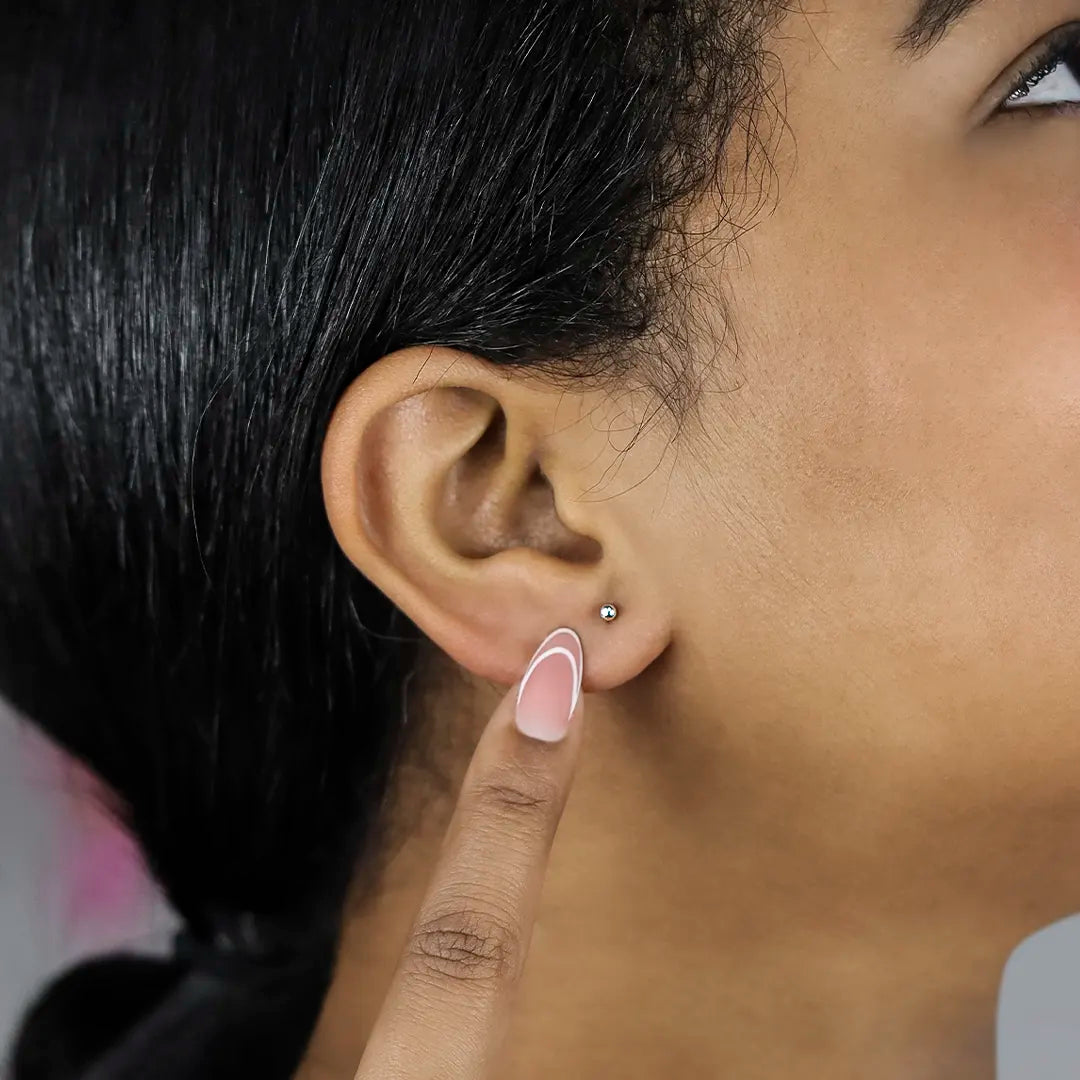 Oreja de mujer con topito de esfera lisa de 2.5mm en oro blanco de 18 quilates, hechos en Joyería Caracas. 