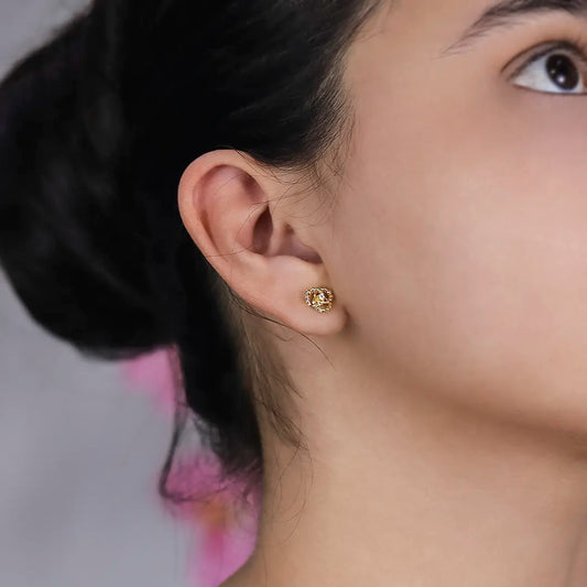 Oreja de mujer con topito en forma de espiral de esfera en oro amarillo de 18 quilates y cristal de color blanco en el centro, hecho en Joyería Caracas. 