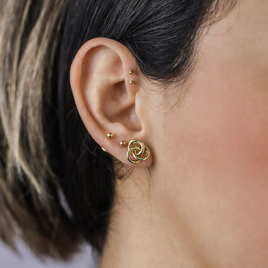 Oreja de mujer con topito en forma de espiral en oro amarillo de 18 quilates, hechos en Joyería Caracas. 