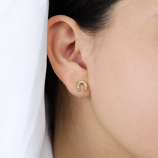 Oreja de mujer con topitos en forma de herradura en oro amarillo de 18 quilates, hecho en Joyería Caracas. 