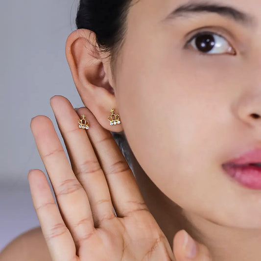 Oreja de mujer con topito en forma de corona en oro amarillo de 18 quilates con 3 cristales de color blanco, hechas en Joyería Caracas. 