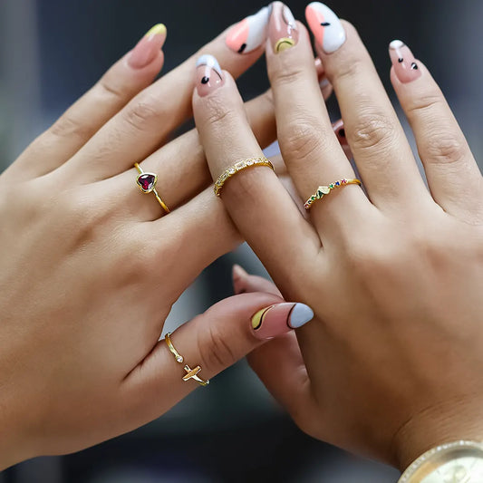 Mano de mujer con anillo en oro amarillo de 18 quilates con cristal en forma de corazón de color rojo, hecho en Joyería Caracas. 