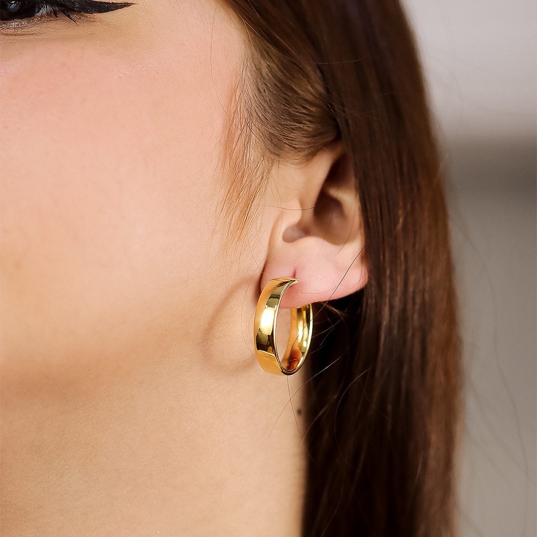 Oreja de mujer con candongas de medio tubo en oro amarillo de 18 quilates de Joyería Caracas. 