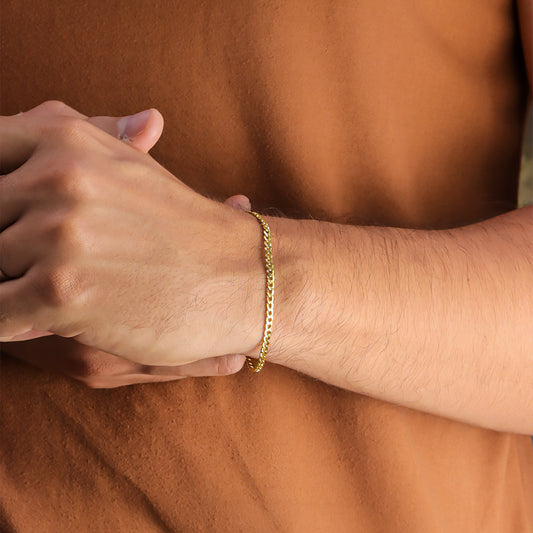 Mano de hombre con pulsera en tejido cubano en oro amarillo de 18 quilates de Joyería Caracas. 