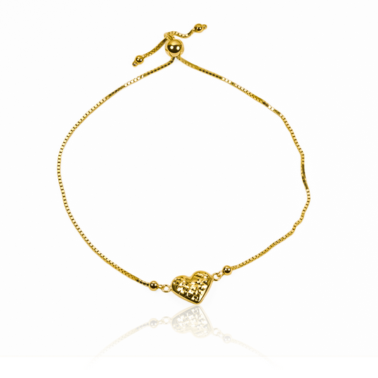 Esta pulsera de diseño exclusivo, con un corazón corrugado en una esfera de oro de 18K, es una verdadera joya de Joyería Caracas. Con garantía de por vida, es el regalo perfecto para demostrar amor eterno. Eleva tu estilo con esta pieza única y atemporal.