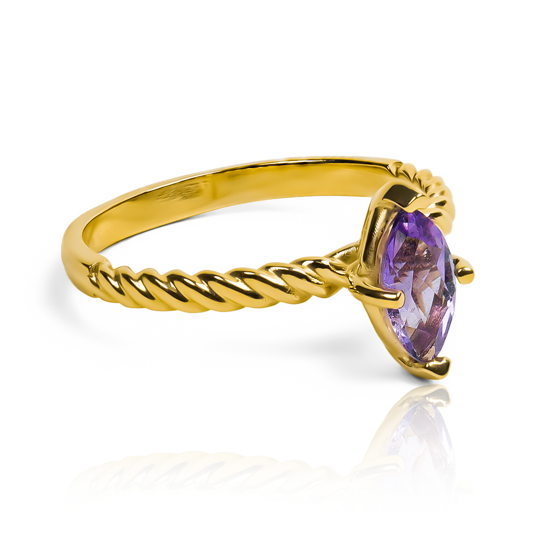  anillo exclusivo de Joyería Caracas es una verdadera obra de arte. Confeccionado en oro 18k, presenta una impresionante forma de marquesa con una piedra preciosa amatista en el centro. 