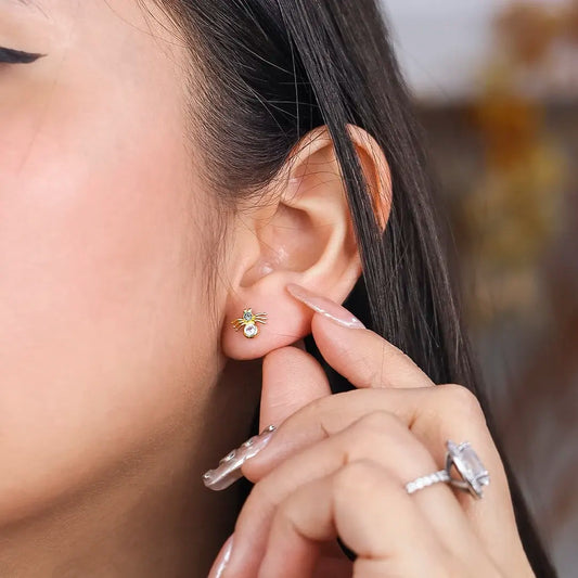 Oreja de mujer con topito en forma de arañita en oro amarillo de 18 quilates con 2 cristales de color blanco, hecho en joyería caracas. 