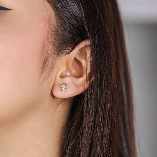 Oreja de mujer con topito en forma de cruz en oro amarillo de 18 quilates con 6 cristales de color blanco, hecho en Joyería Caracas. 