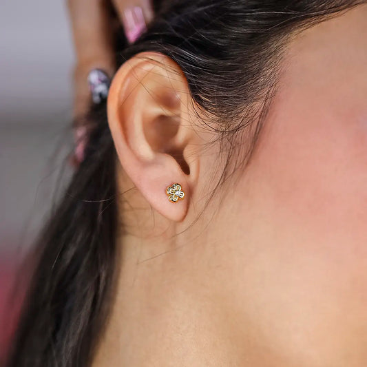 Oreja de mujer con topito en forma de flor en oro amarillo de 18 quilates con cristal de color blanco en el centro, hecho en Joyería Caracas. 