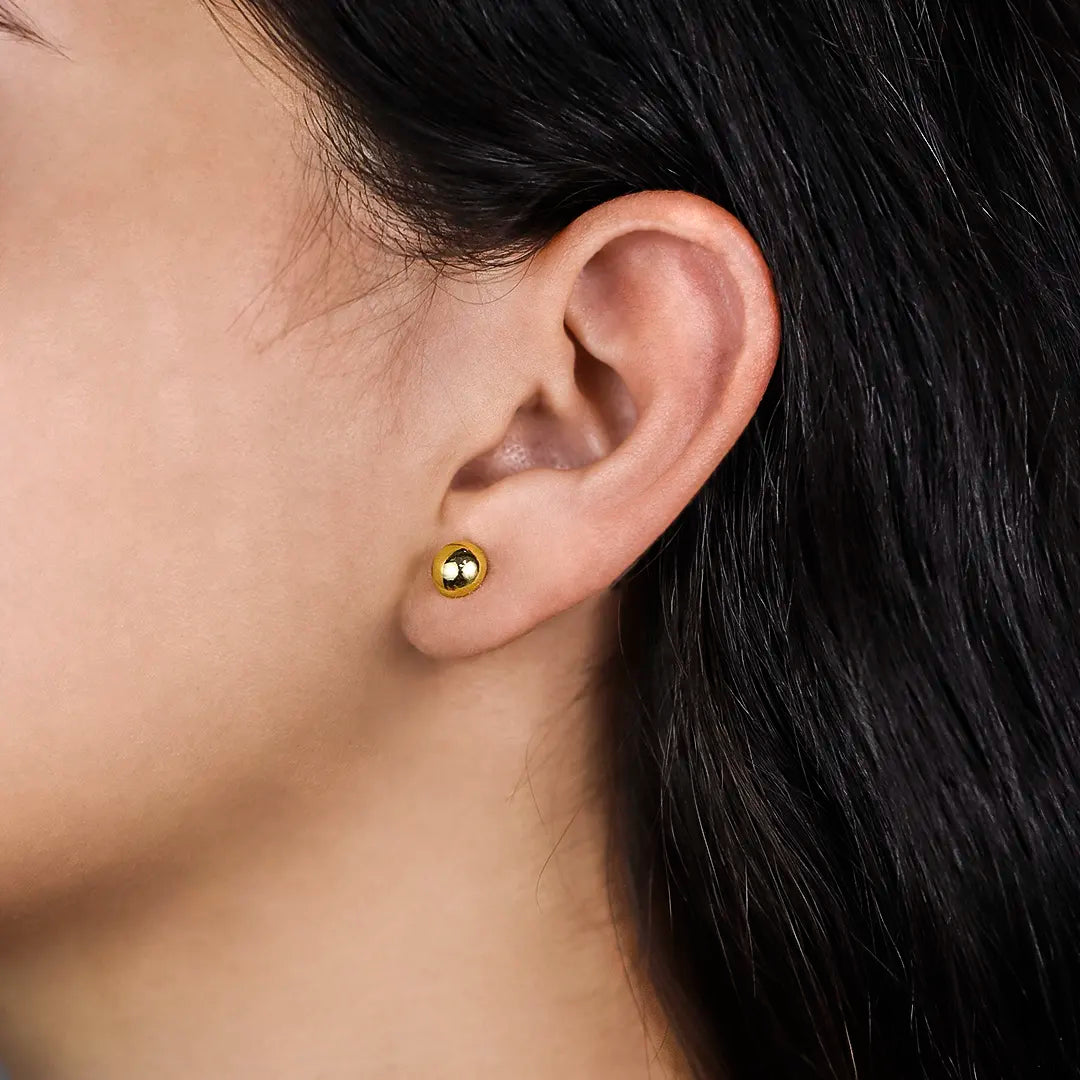 Oreja de mujer con topito de media esfera lisa de 7.0mm en oro amarillo de 18 quilates, hecho en Joyería Caracas. 