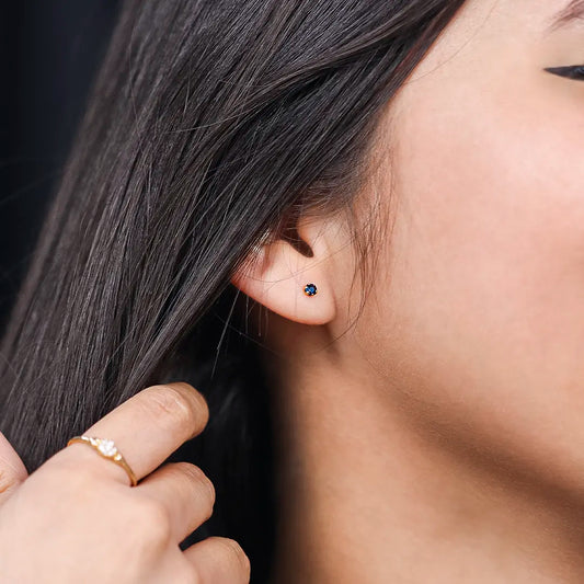 Oreja de mujer con topito en oro amarillo de 18 quilates con zafiro natural de 2.0mm, hecho en Joyería Caracas. 